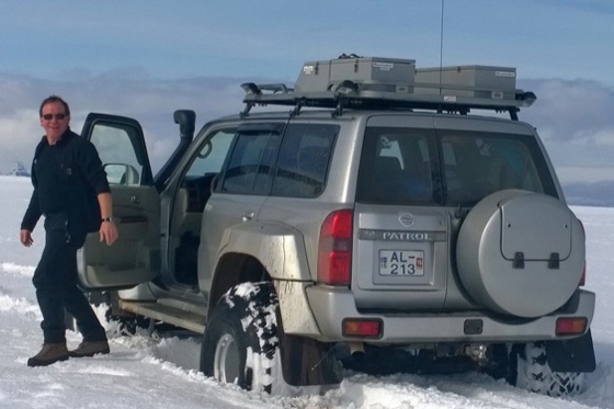 Sølvfarget Nissan Patrol på snø med en person ved den åpne bildøra